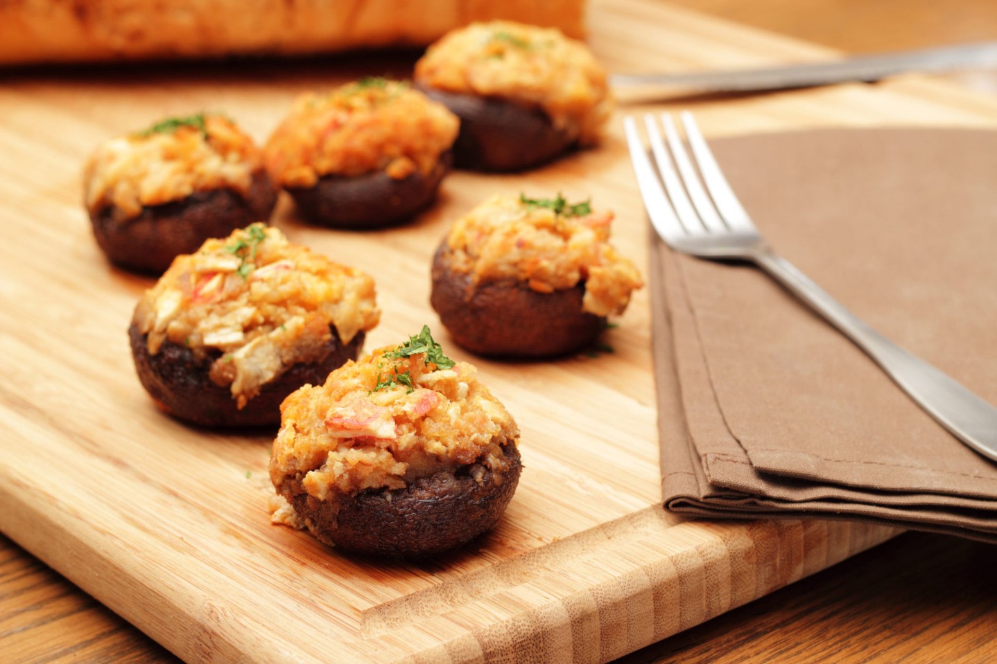 mushroom-crab-appetizer||Photograph of stuffed mushrooms on a cutting board