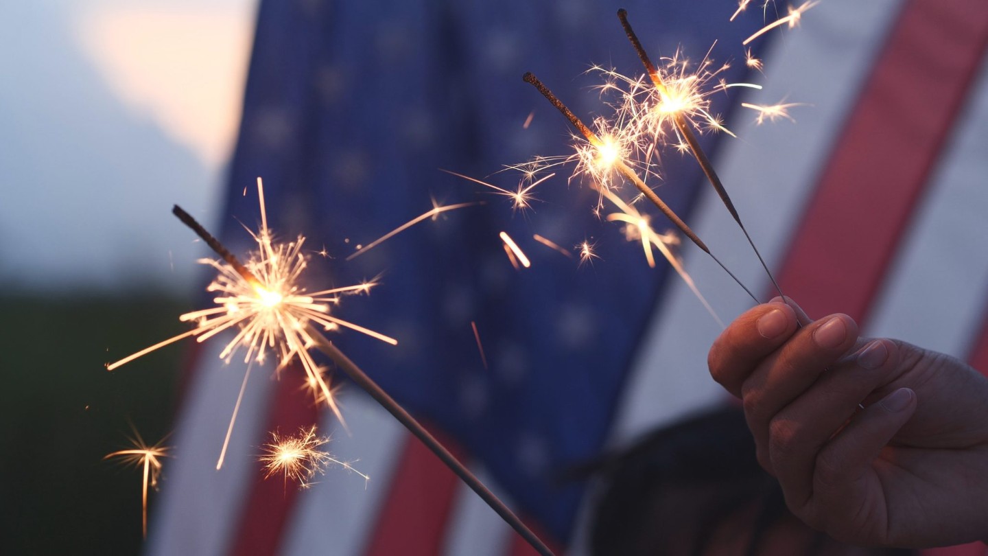 Happy 4th of July Independence Day, Hand holding Sparkler fireworks USA celebration with American flag background. Concept of Fourth of July, Independence Day, Fireworks, Sparkler, Memorial, Veterans||fireworks