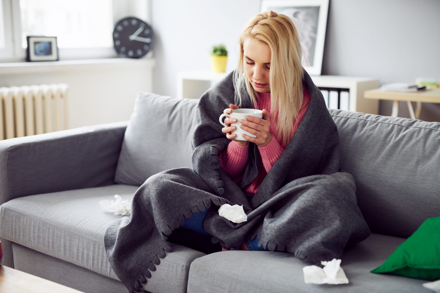 Young woman drinking tea while covered in blanket||thumb-side||thumb-up||thumb-down