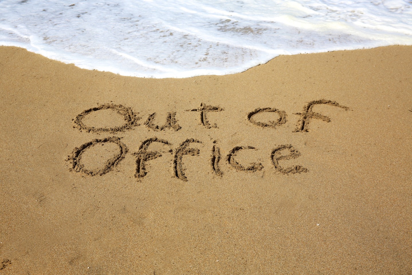 out of office written in the sand