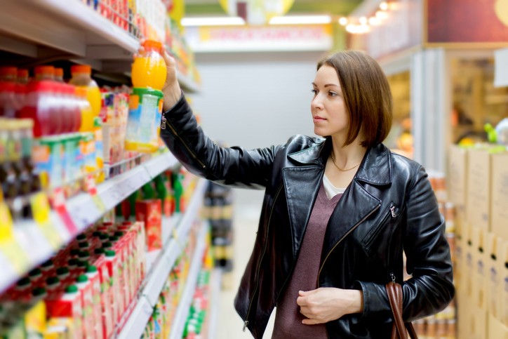woman in a supermarket buying a bottle of juice