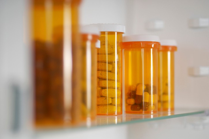 Bottles of pills in cabinet, close-up