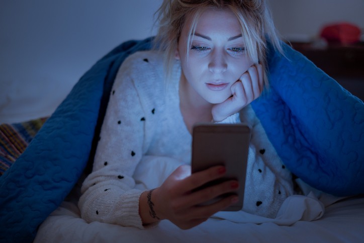 Teenage Girl Reading Text Message Before Bed||Emit Blue Light Graphic