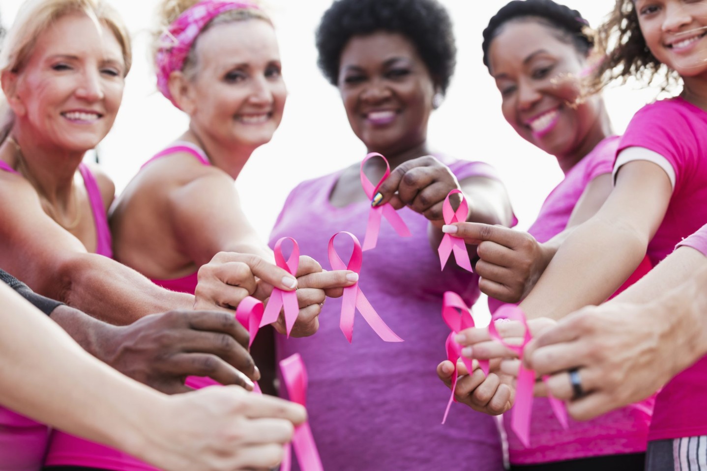 Group of women in pink, breast cancer awareness ribbons||Unrecognizable female gynocologist looking at a mammogram at the hospital