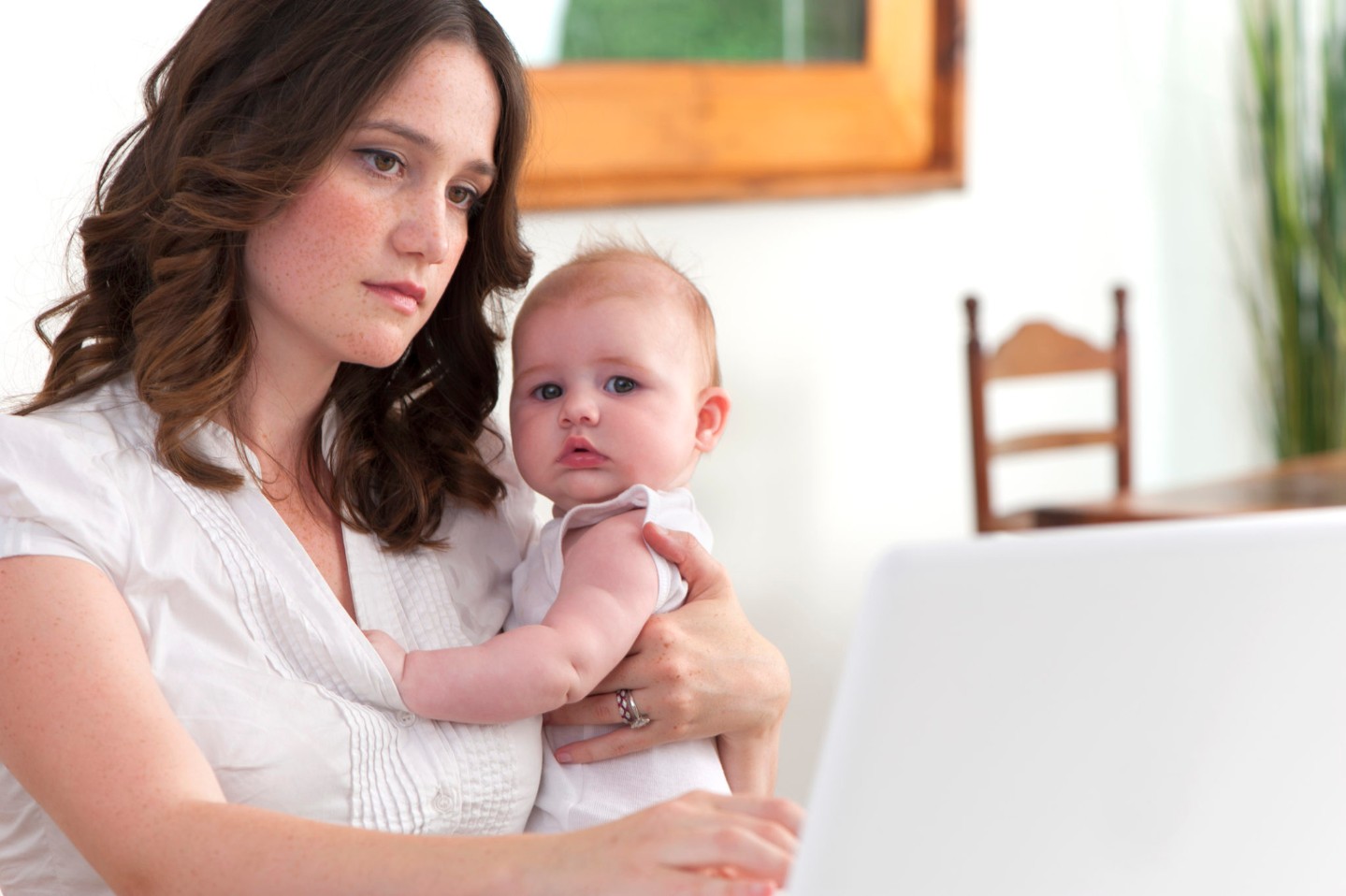 Mother working from home with baby looking stressed||Mother with Postpartum Depression