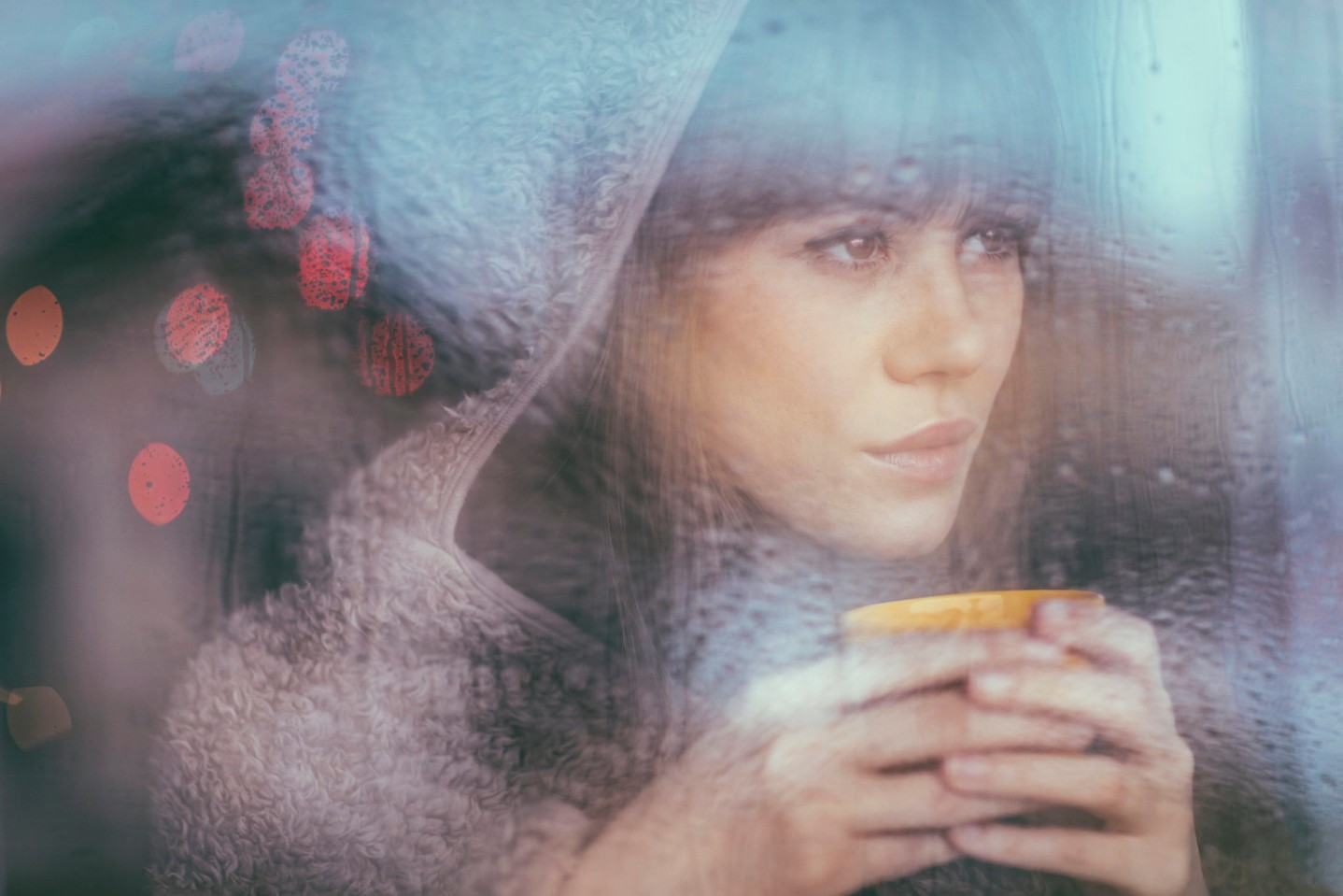 woman looking out window on rainy day