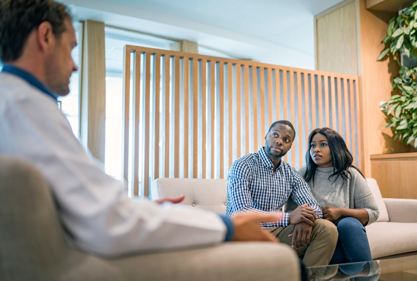 Worried young couple listening to doctor in a hospital.