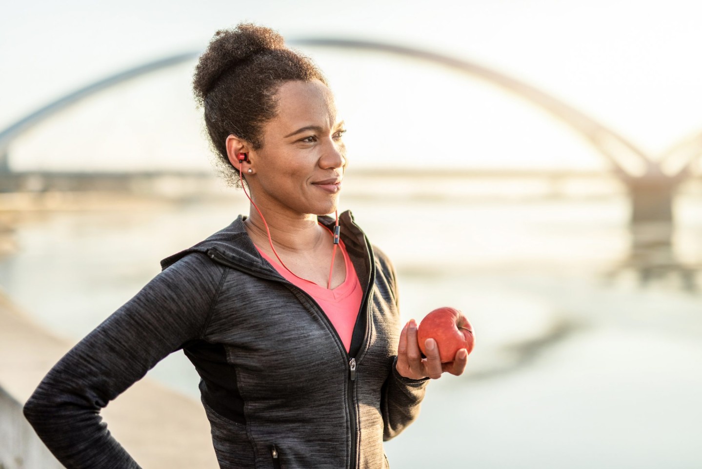 Happy African American Athletic Woman Eating An Apple After Exercise