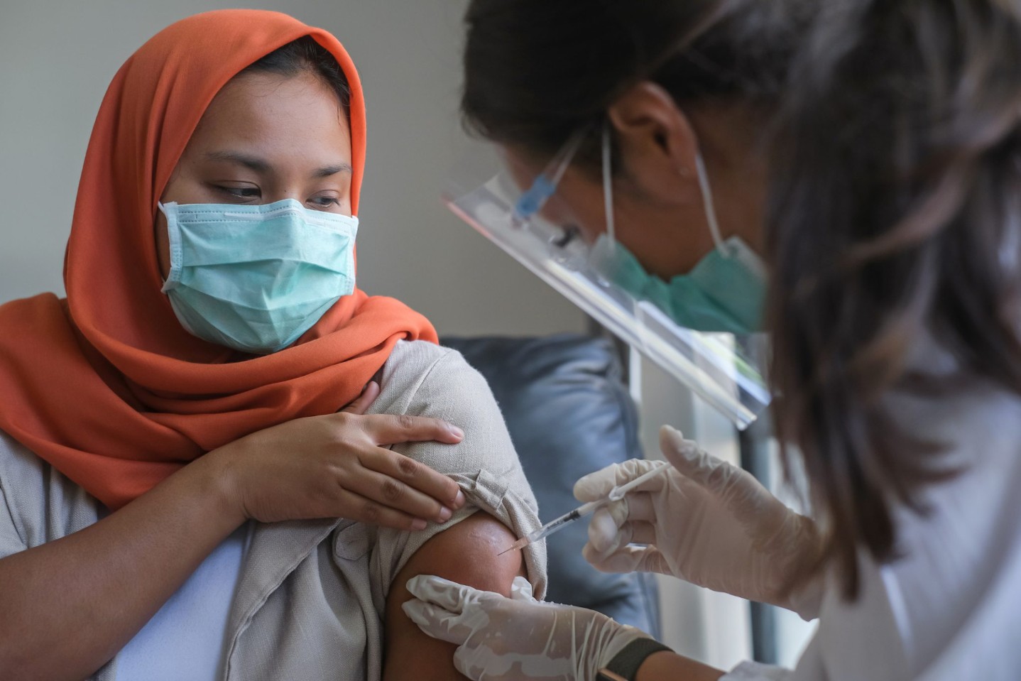 Asian Female Doctor Giving a Patient the Shot of Vaccine.