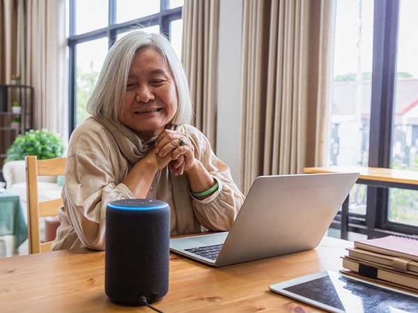 Woman on laptop looking at smart device