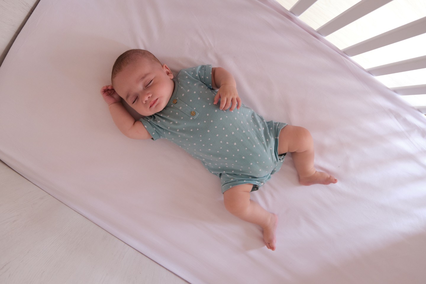 baby sleeping on his back in crib