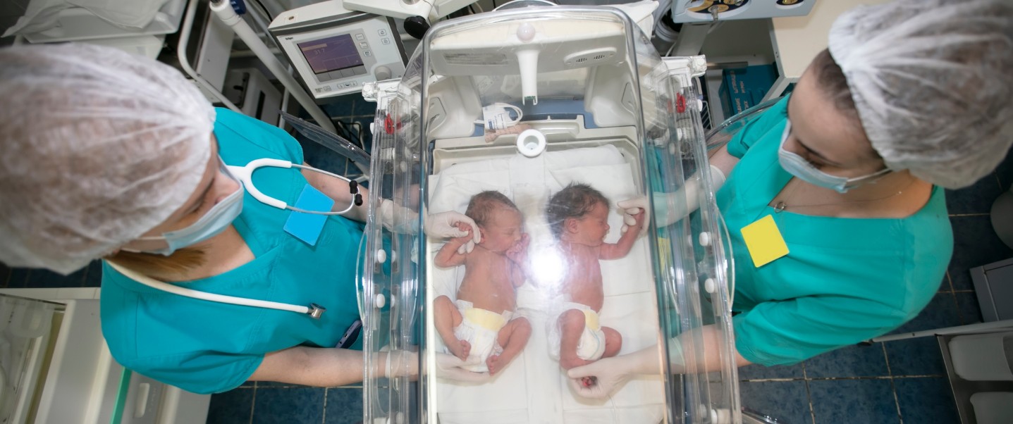 two nurses working with two nicu babies
