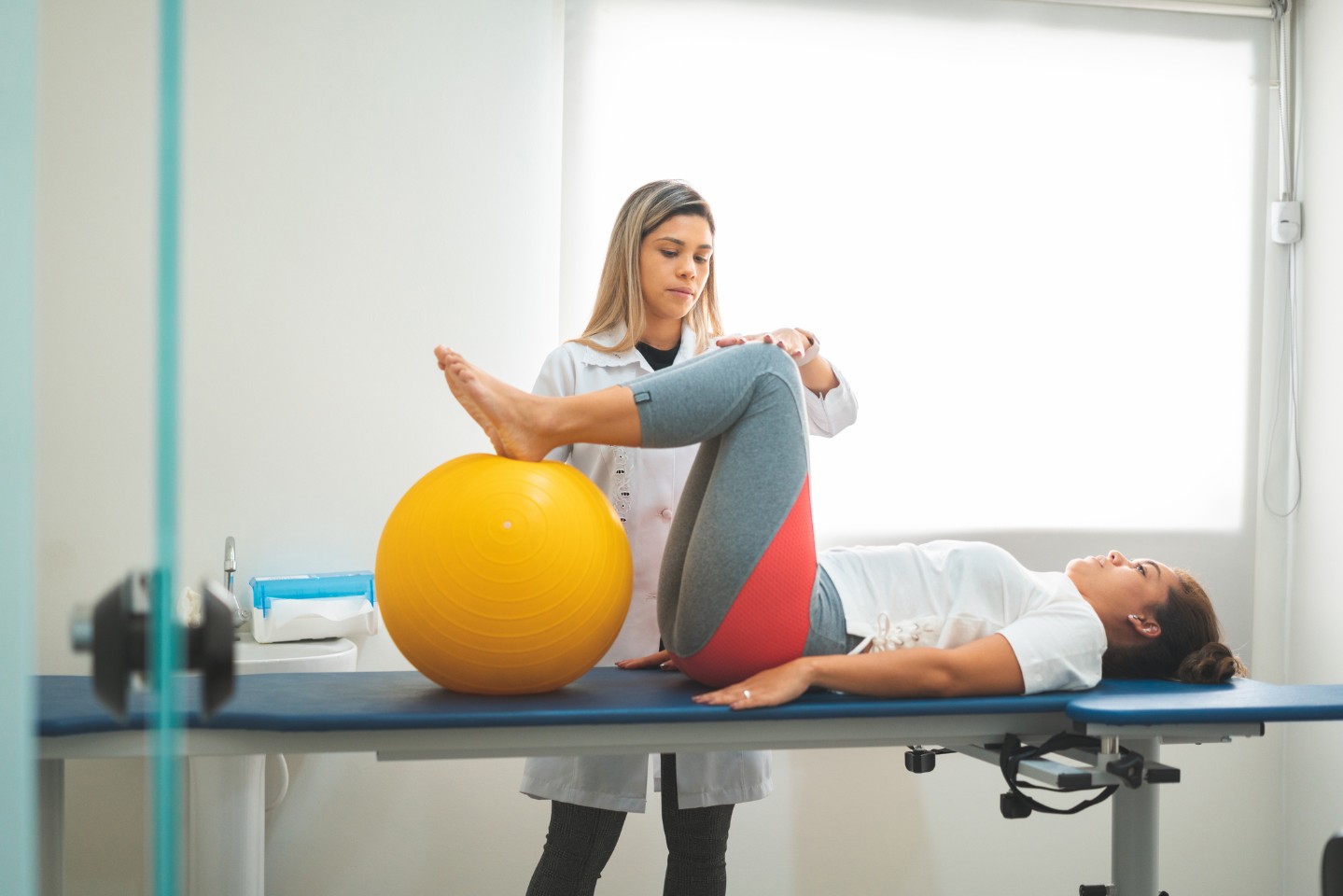 Pelvic therapist helping woman with exercises