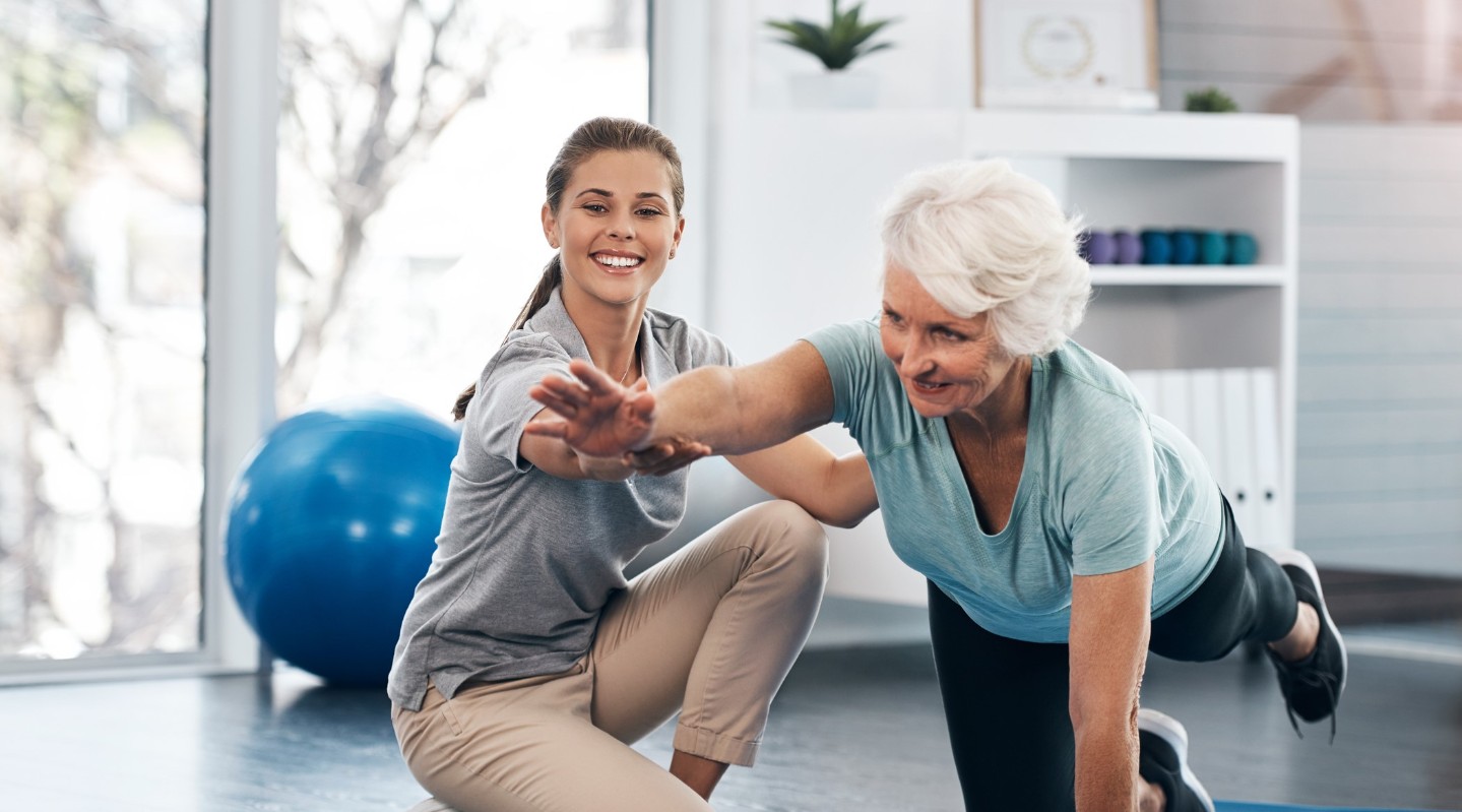 elderly woman working with a physical therapist