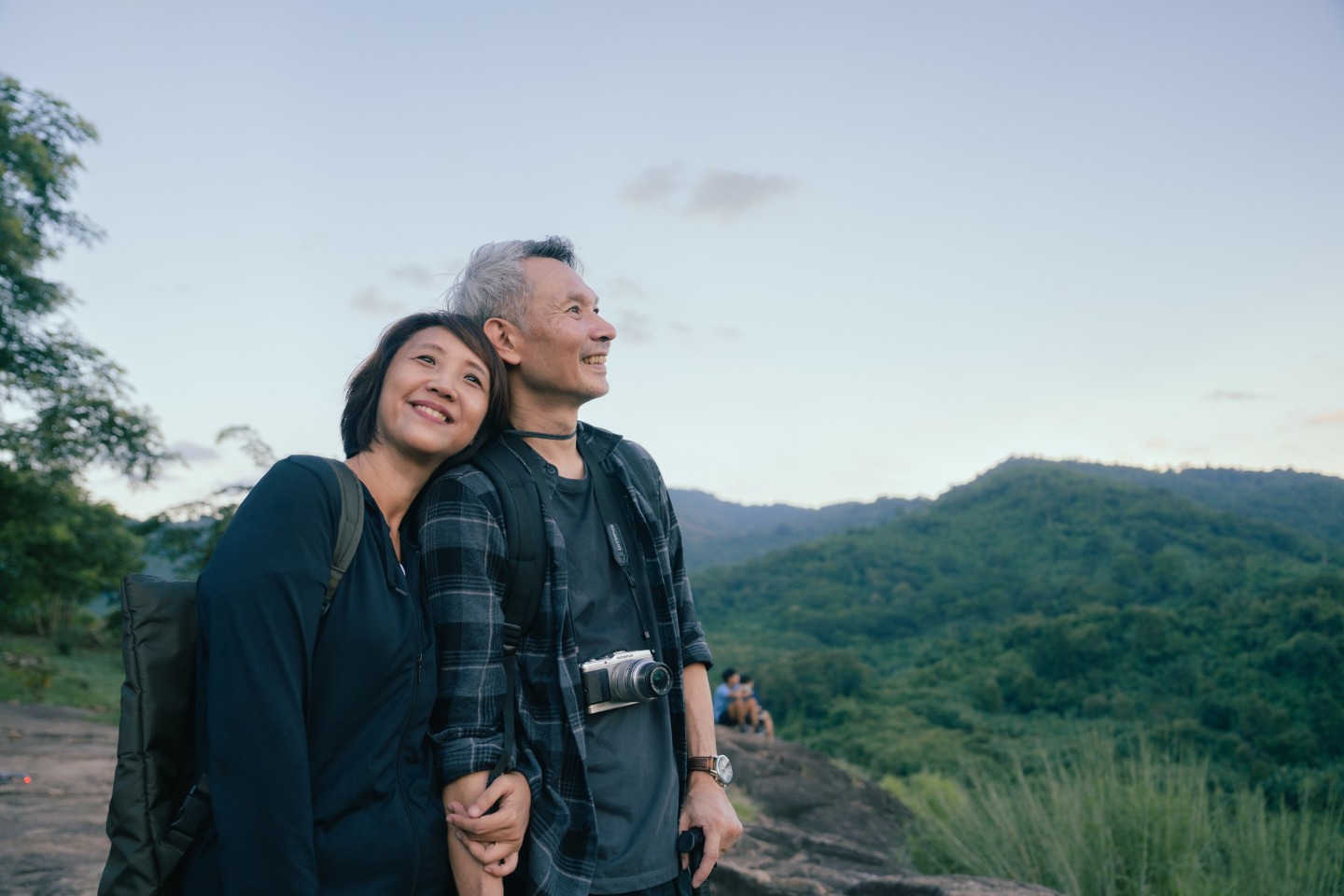 Older Asian couple smiling outdoors enjoying life